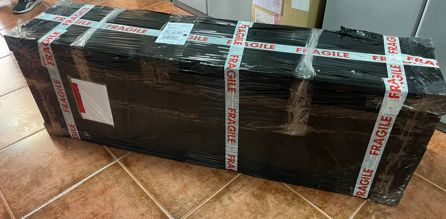 Megan 1/1 replica doll by NECA in a large black crate wrapped in plastic with FRAGILE tape