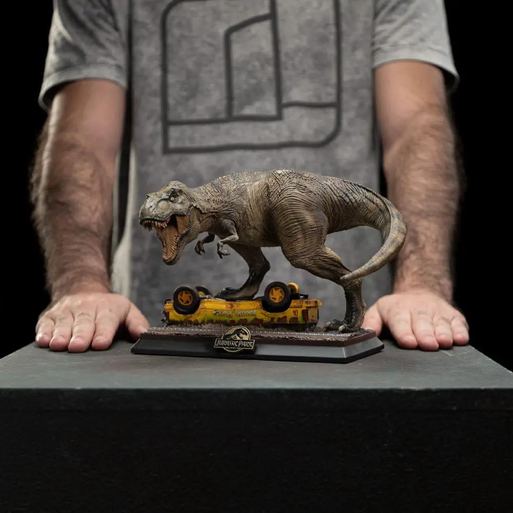 Jurassic Park Icons T-Rex Attack statue, 15 cm; brown dinosaur attacking a yellow car on a display base by Iron Studios