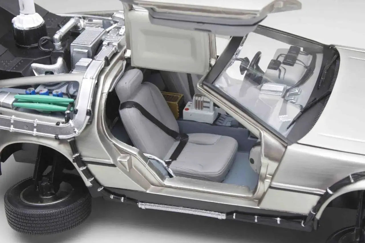 DeLorean time machine 1/18 diecast toy car, silver metal body with gull-wing doors and exposed engine