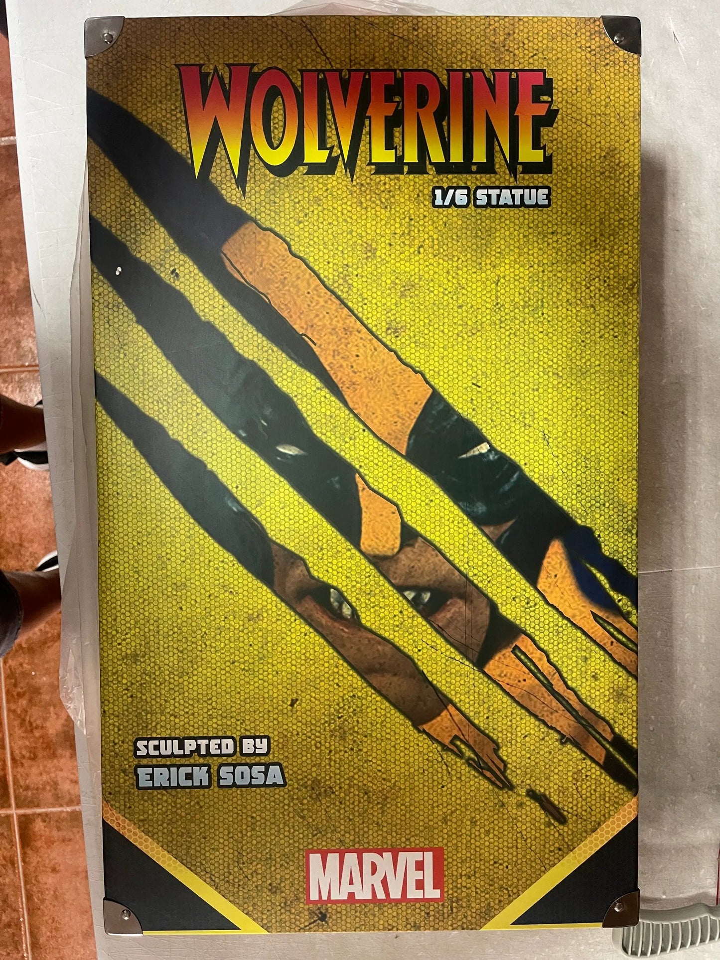 Wolverine 1/6 statue packaging by SEMIC Distribution featuring a yellow hex pattern and Marvel logo