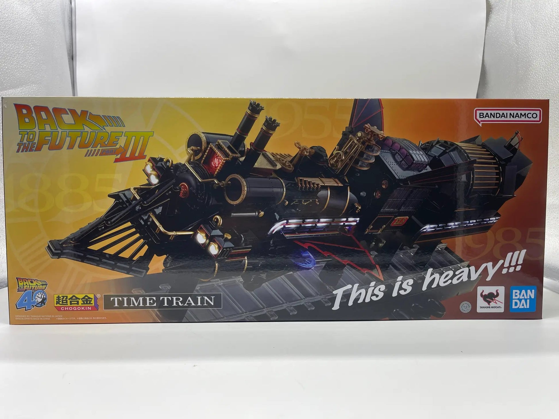 Chogokin Time Train action figure by Bandai Namco; black train with gold accents on orange packaging.