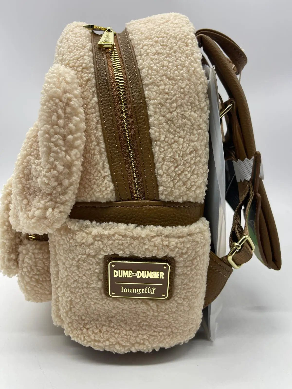 Mochila Loungefly Dumb and Dumber sherpa beige con ribete de cuero marrón y cremallera dorada