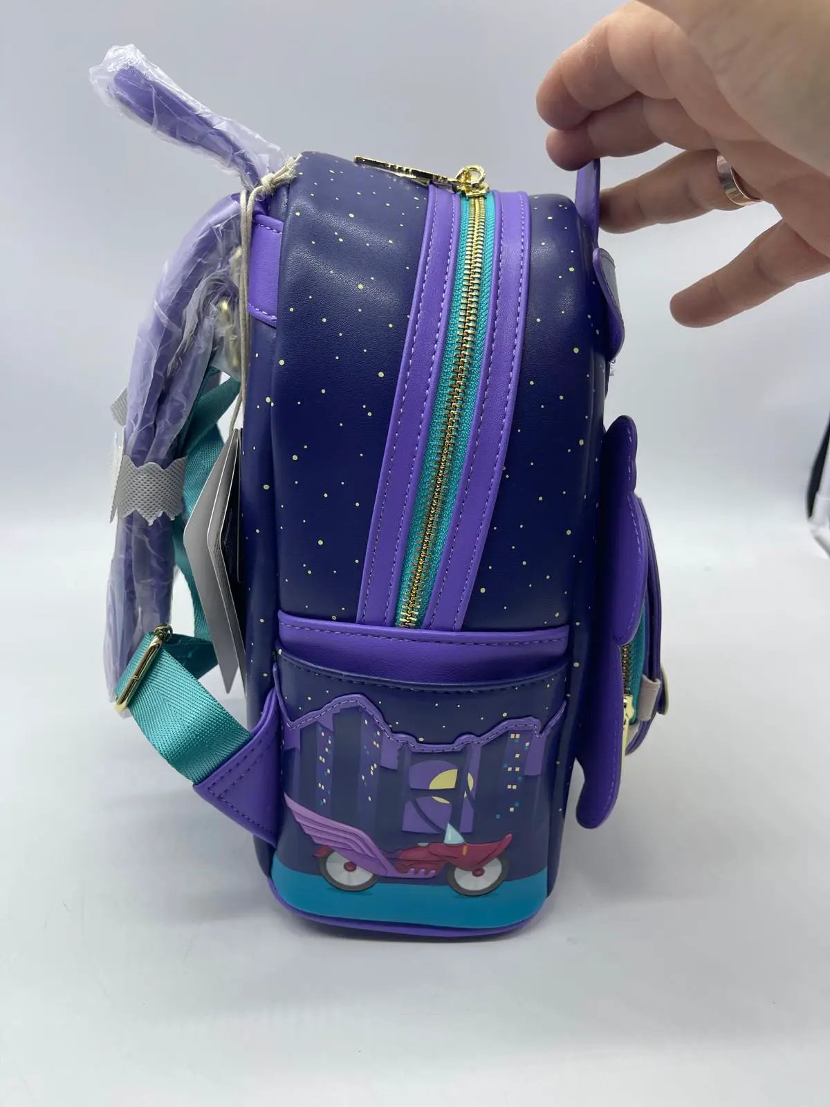 Pato Darkwing Loungefly Mini Backpack; navy body with gold speckles, purple trim, turquoise zipper, and teal straps.