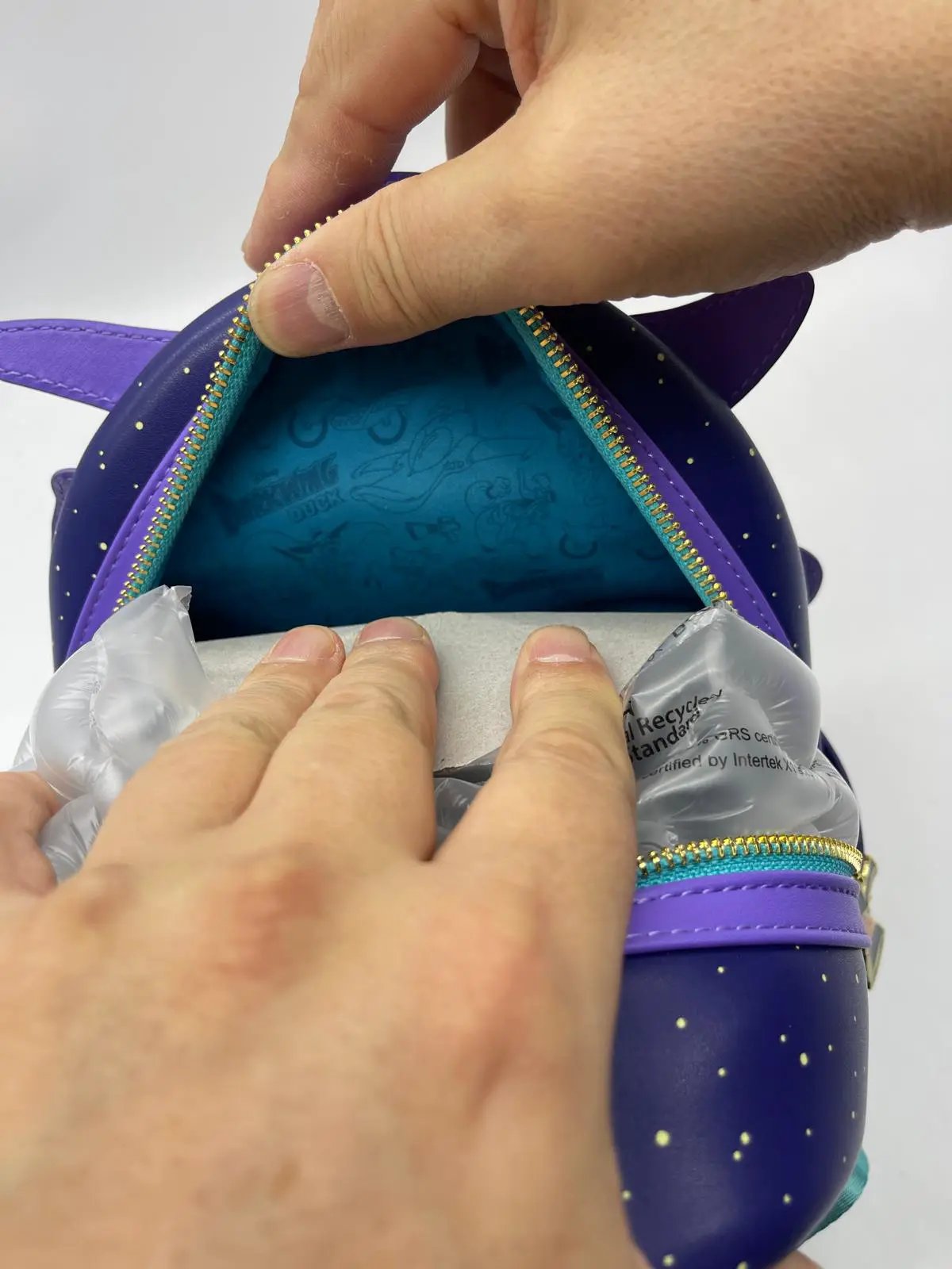 Pato Darkwing mini backpack by Loungefly, purple faux leather with teal interior and gold zippers.