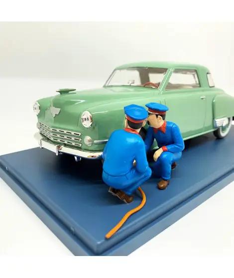 Automóvil a escala 1/24 MOULINSART Tintin Studebaker verde con dos figuras azules y manguera naranja sobre base azul