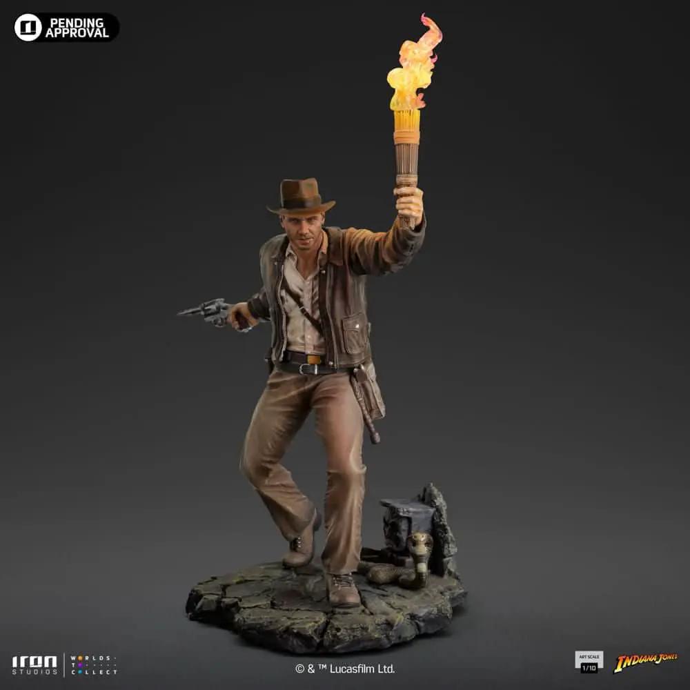 Indiana Jones statue by Iron Studios, Art Scale 1/10, wielding flaming torch and pistol, brown jacket on rocky base.