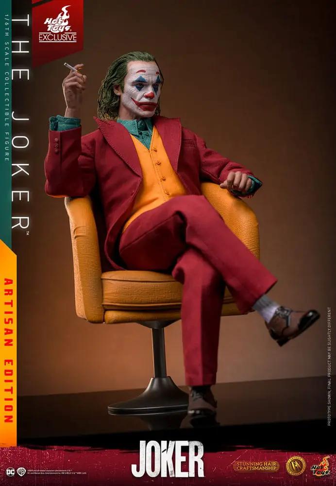 Figura de acción 1/6 Joker Artisan Edition de HOT TOYS, sentado en sillón naranja con traje rojo y maquillaje de payaso.