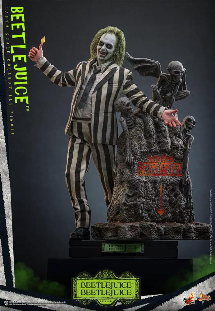 Beetlejuice 1/6 scale figure by HOT TOYS with striped suit and green hair on a rocky base featuring Beetlejuice logo.