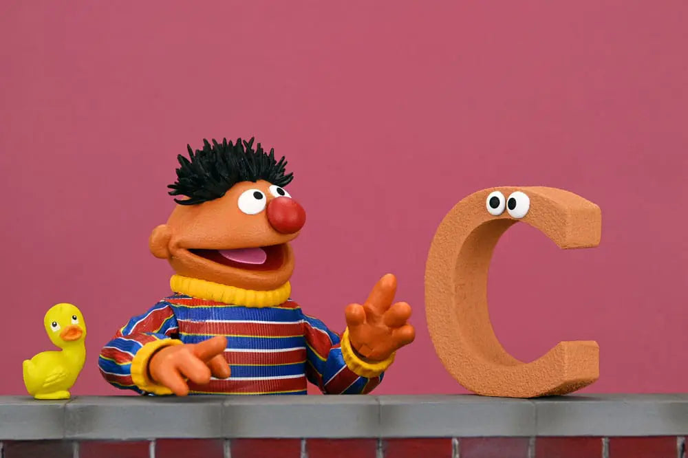 Figura Ultimate Ernie 18 cm Sesame Street; NECA; Ernie naranja con camiseta a rayas, junto a patito amarillo y letra C