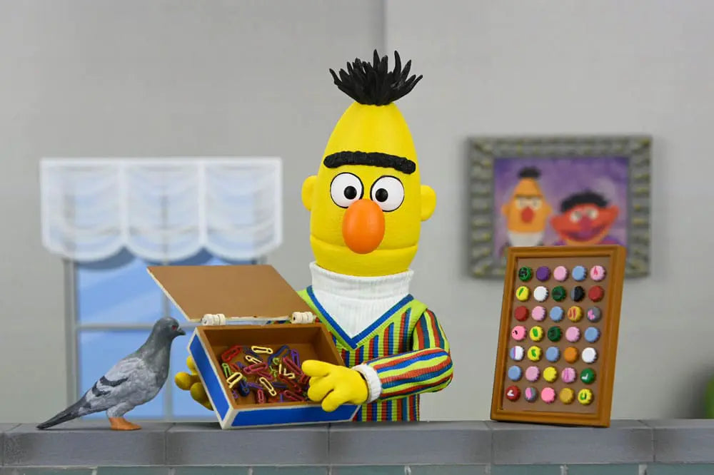 NECA Sesame Street Bert 18 cm figure; yellow Bert in striped sweater, holding a box of paper clips beside a bead tray.