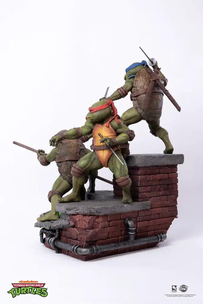 Tortugas Ninja estatua 1/6 en diorama de película; tres tortugas verdes en muro de ladrillos con tuberías, de PURE ARTS