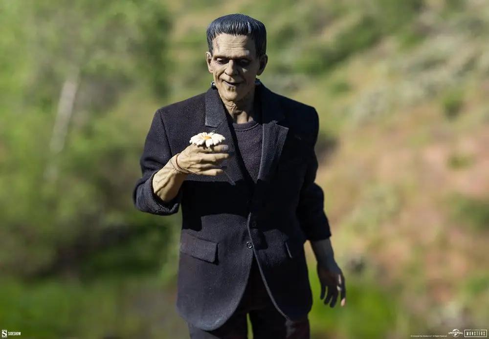Frankenstein 1/6-scale action figure by Sideshow Collectibles in a black suit, holding a white daisy outdoors.