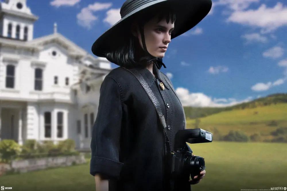 Lydia Deetz 1/6 scale action figure by Sideshow Collectibles in black dress with wide-brim hat, holding a camera, 25 cm