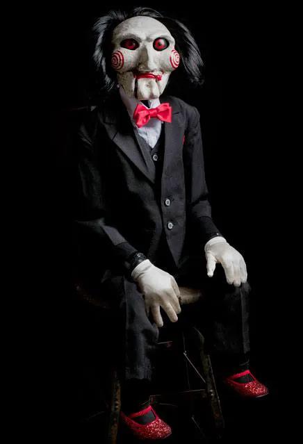 Saw Billy 119 cm doll replica by Trick or Treat Studios in a black suit with red bow tie and masked face.